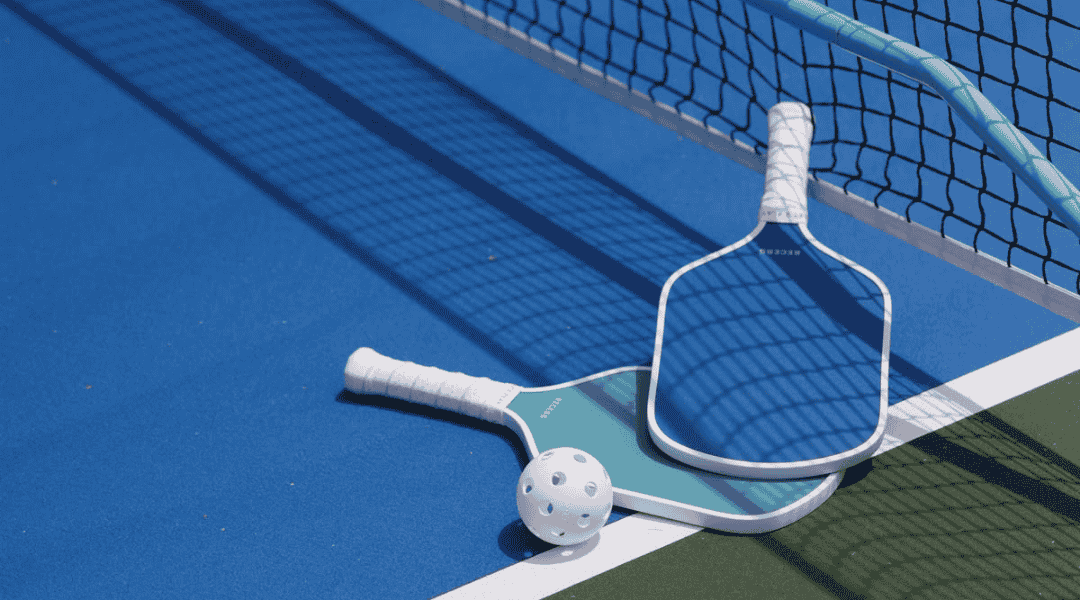 Vợt và bóng Pickleball trên sân thi đấu Pickleball